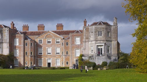 Visitors on the lawn in autumn with exterior of house in background, Mottisfont, Hampshire